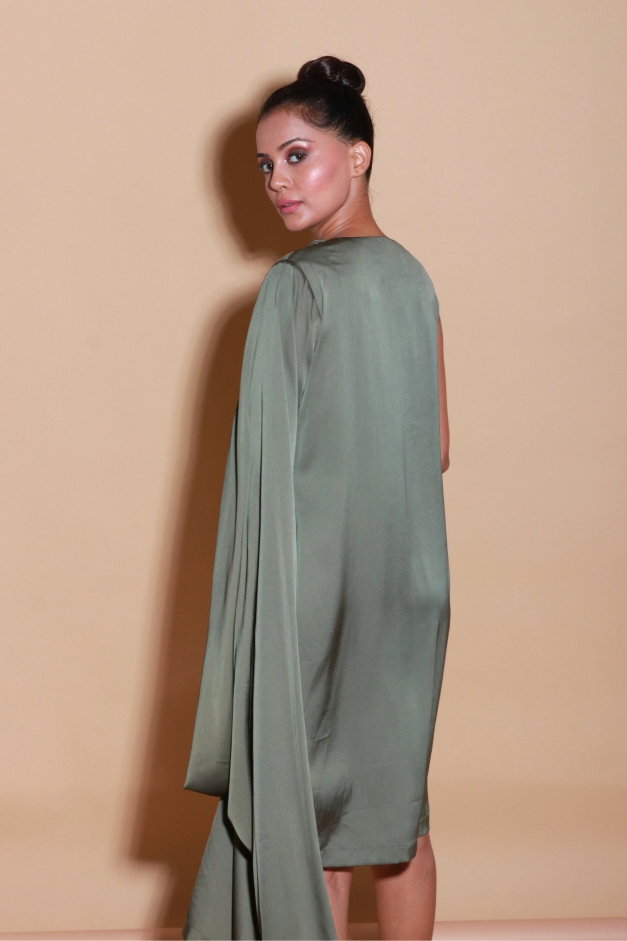 Olive green sleeveless dress with one side drape and neck embellishment.