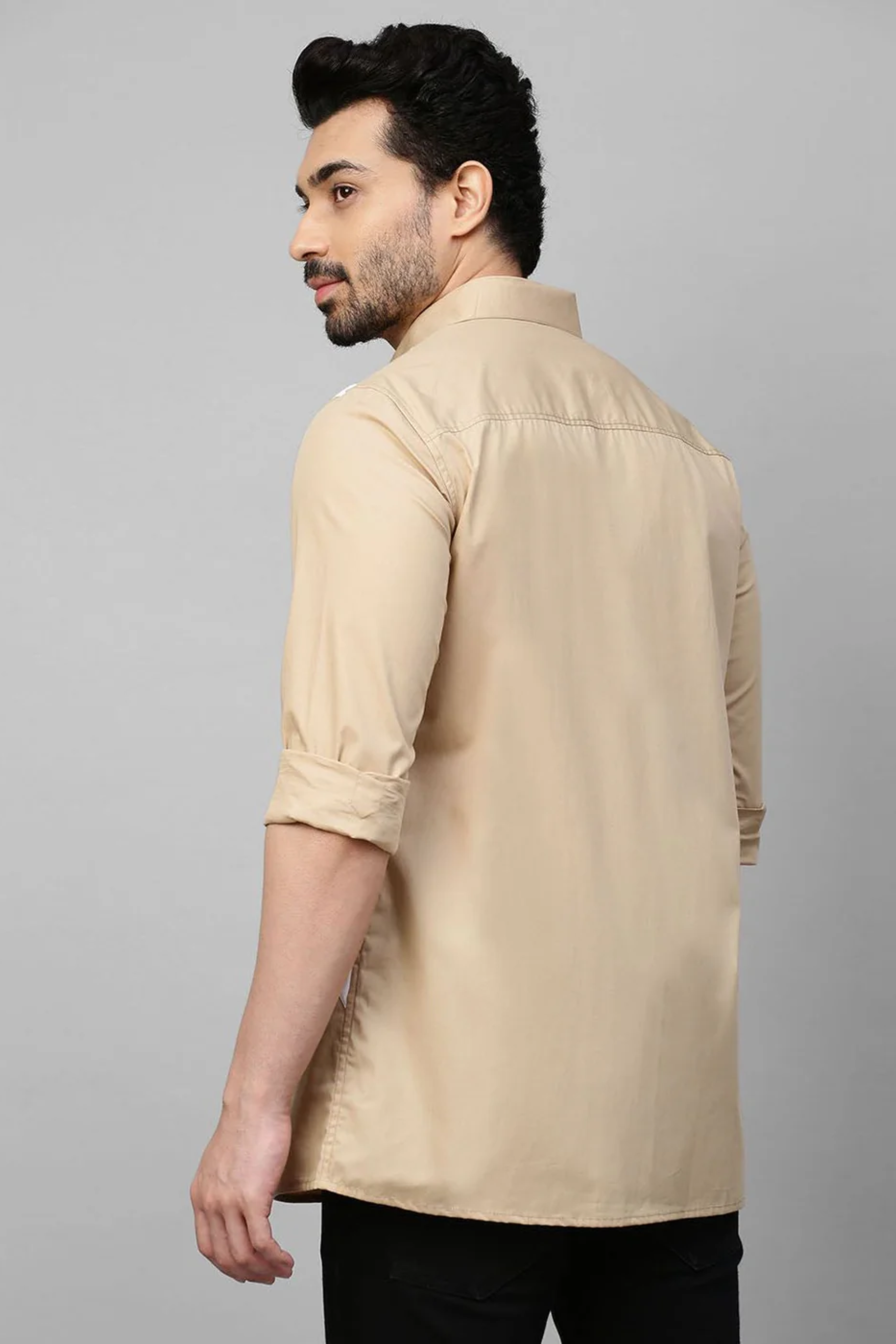 Beige shirt with light blue and white patchwork detailing.