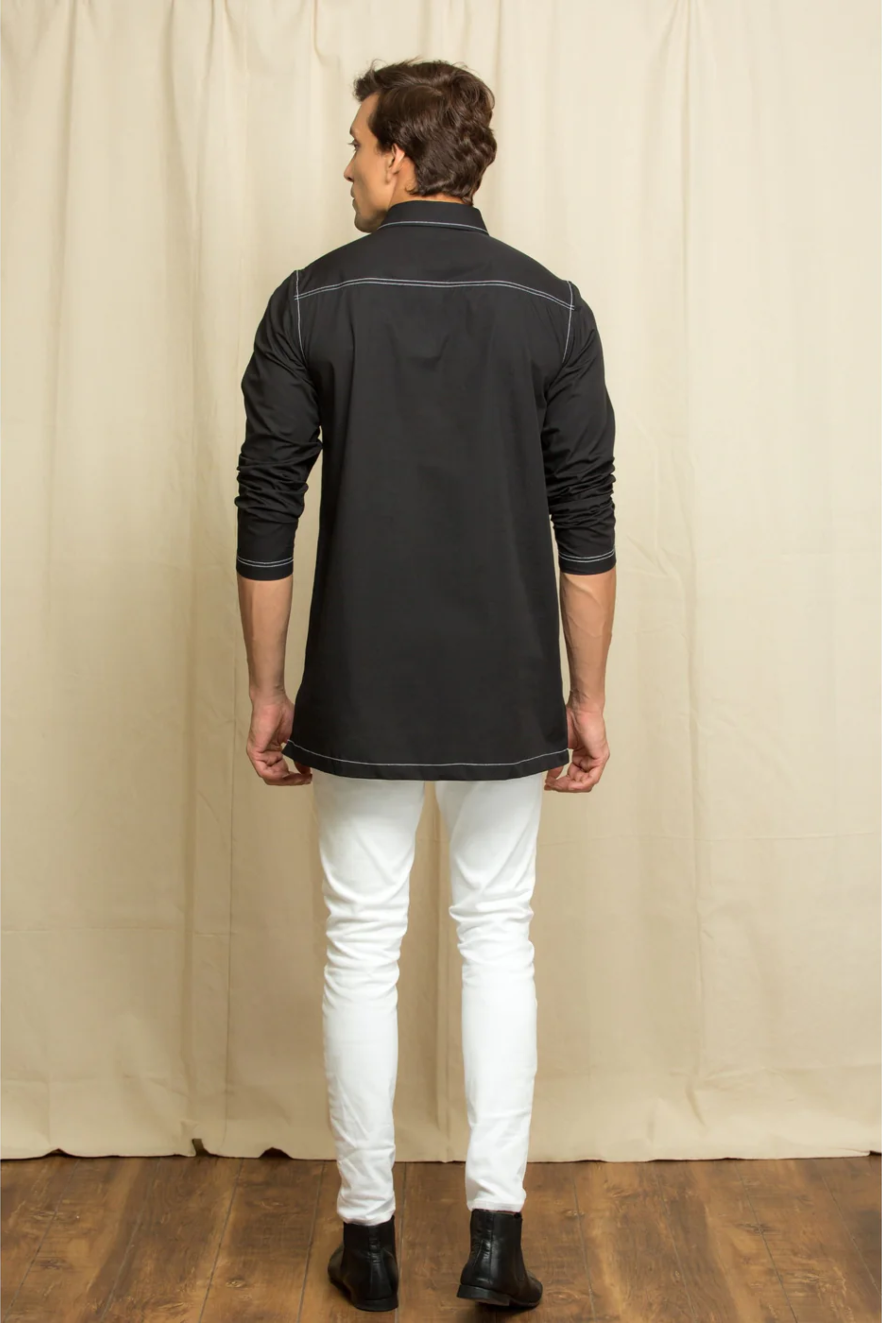 Black kurta shirt with white stitching detailing.