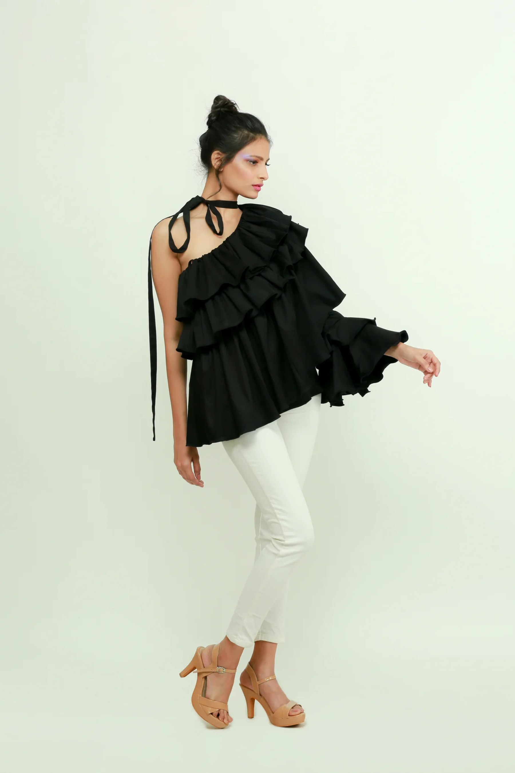 Black one shoulder top features a tie-up collar with ruffles and ruched cuff.