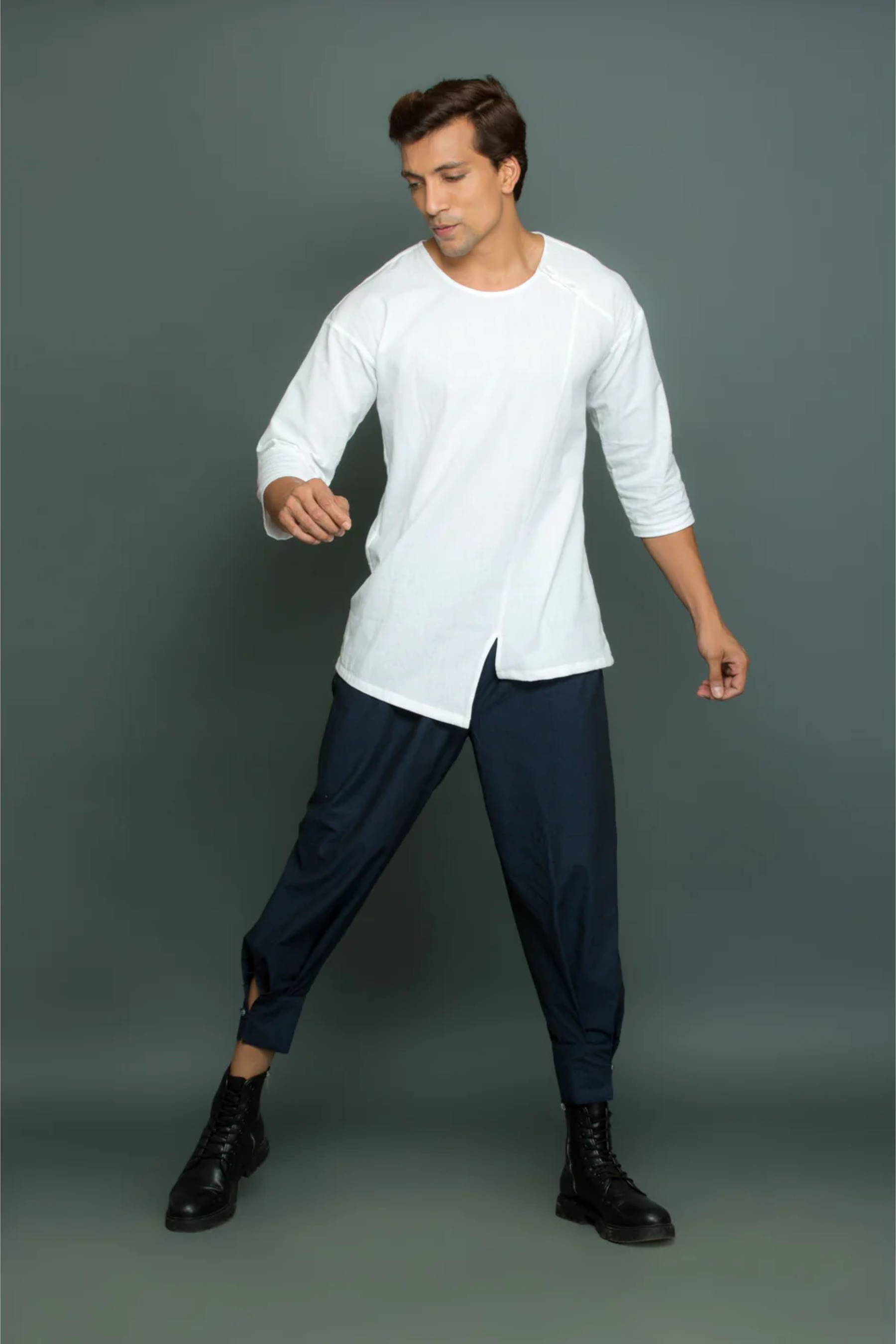 White asymmetric round neck top with cuff pants.