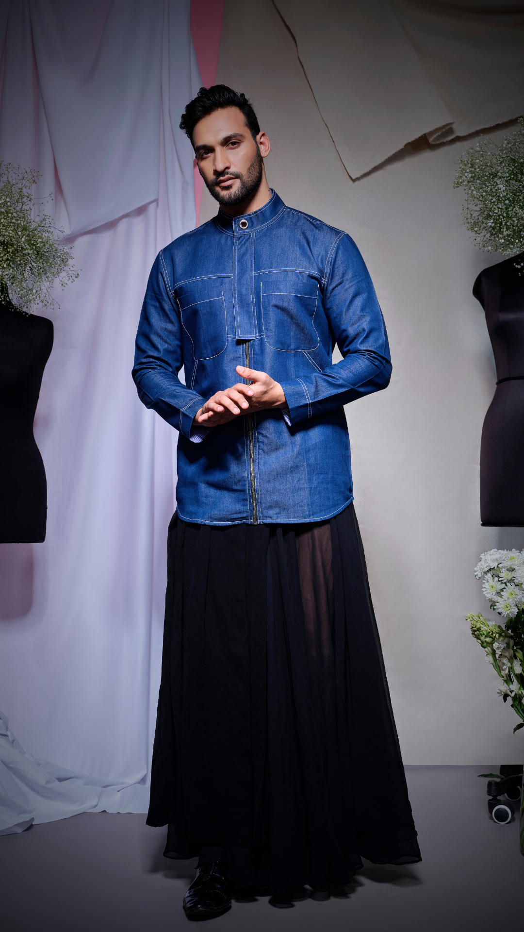 Denim shirt with thick white stitching and half rectangle feature on one side of the placket and eyelet