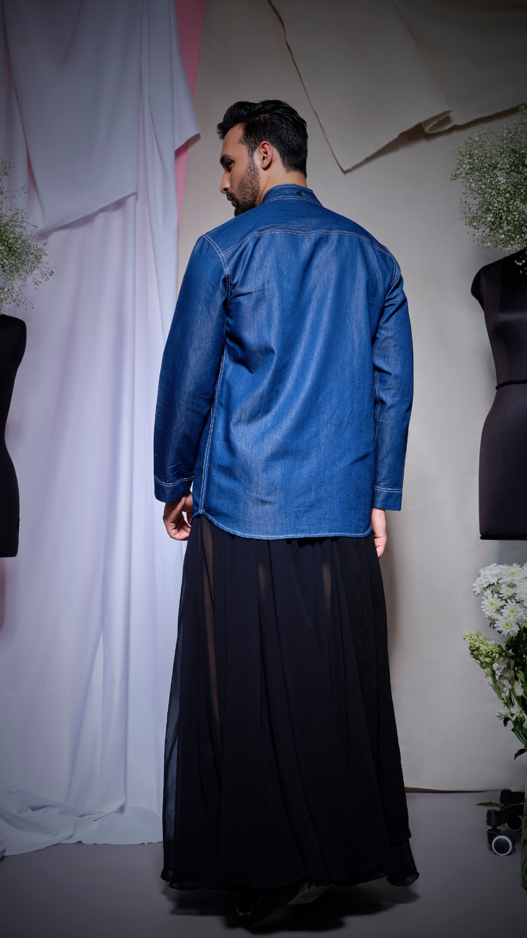 Denim shirt with thick white stitching and half rectangle feature on one side of the placket and eyelet