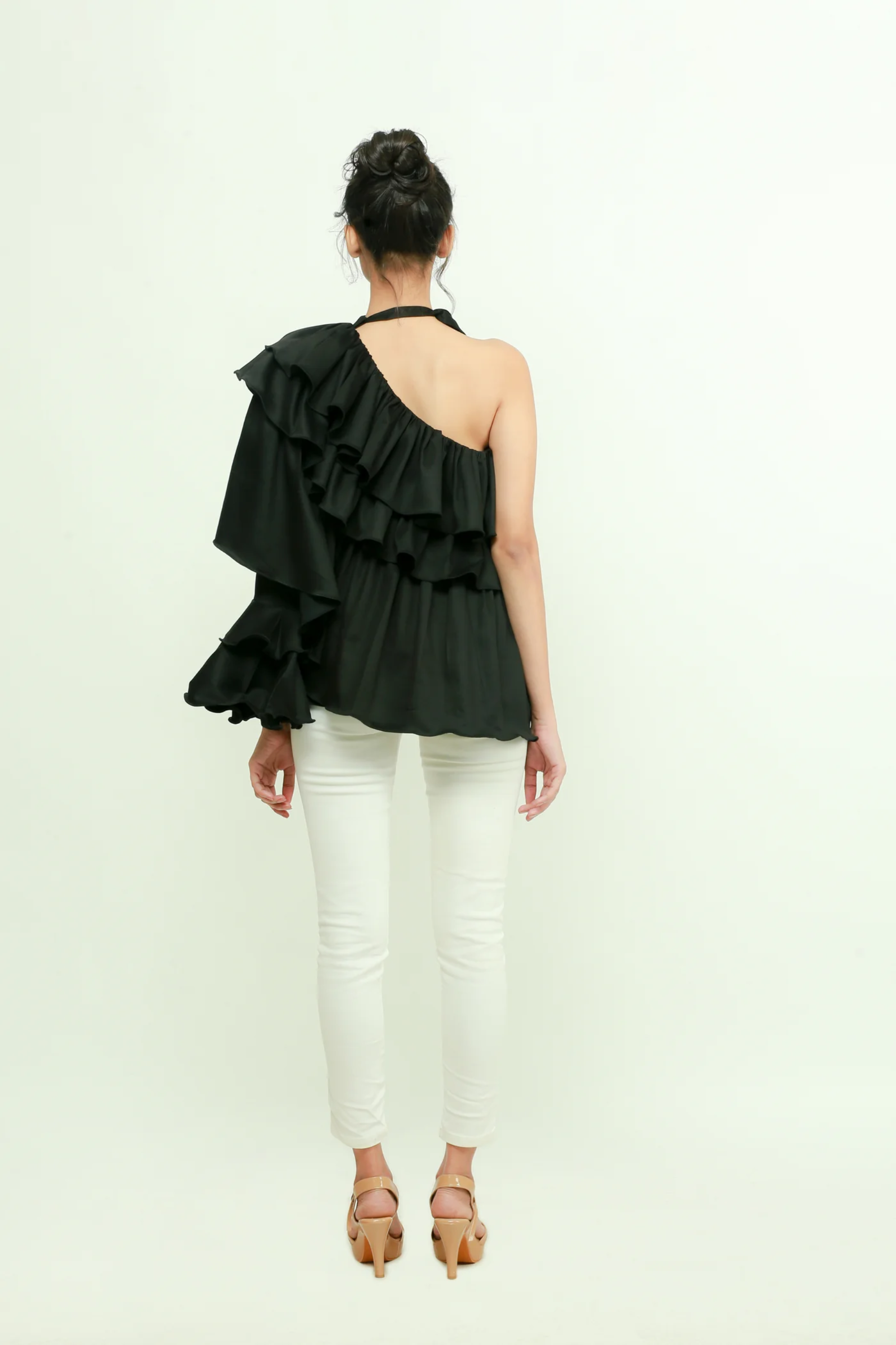 Black one shoulder top features a tie-up collar with ruffles and ruched cuff.