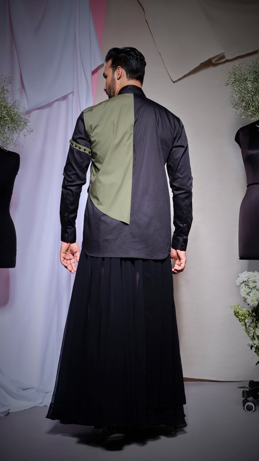 Black shirt with olive green flap on one side and arm band with gunmetal studs and low to high collar