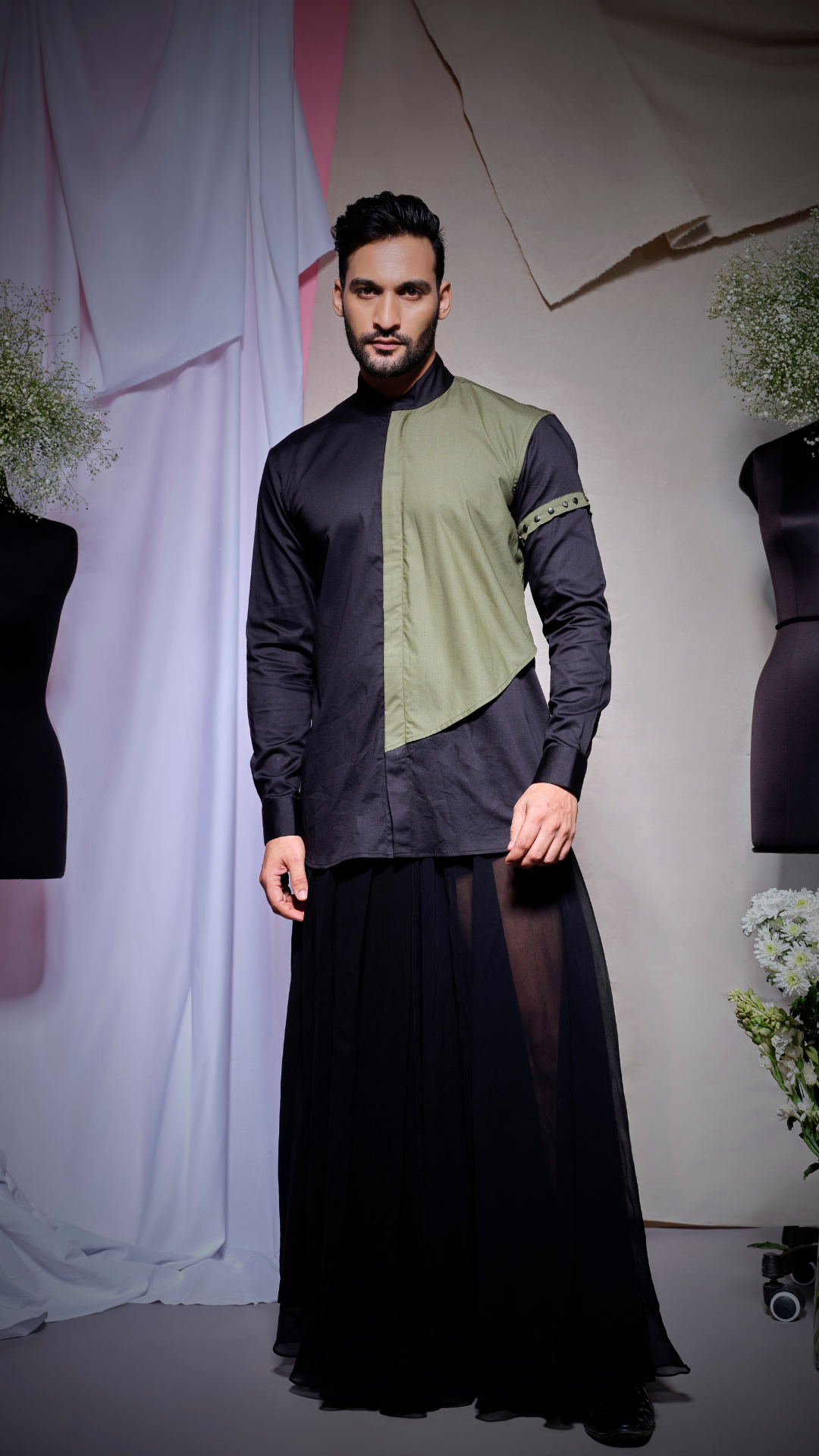 Black shirt with olive green flap on one side and arm band with gunmetal studs and low to high collar