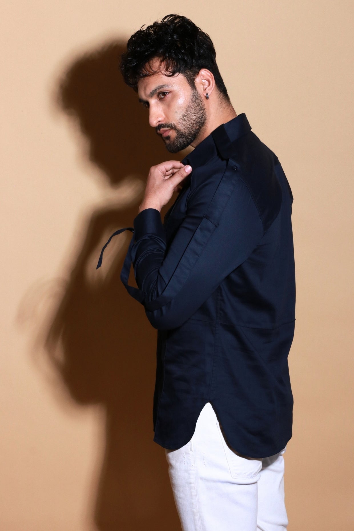 Blue shirt with pintucks and adjustable strap feature on sleeves.