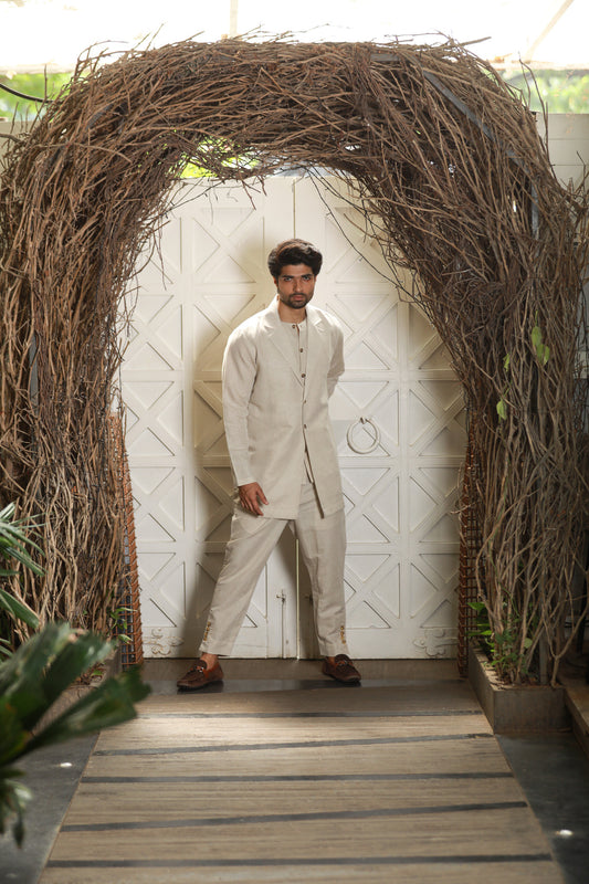 Ecru linen attached waist coat and jacket with narrow pants.