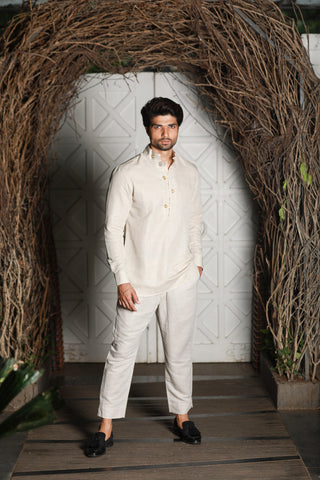 Ecru linen kurta shirt with narrow pants.