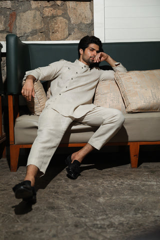 Ecru linen mandarin collar shirt with diagonal placket feature and narrow pants.