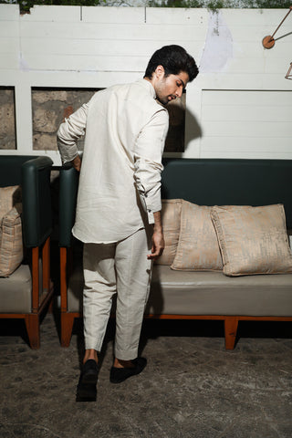 Ecru linen mandarin collar shirt with diagonal placket feature and narrow pants.