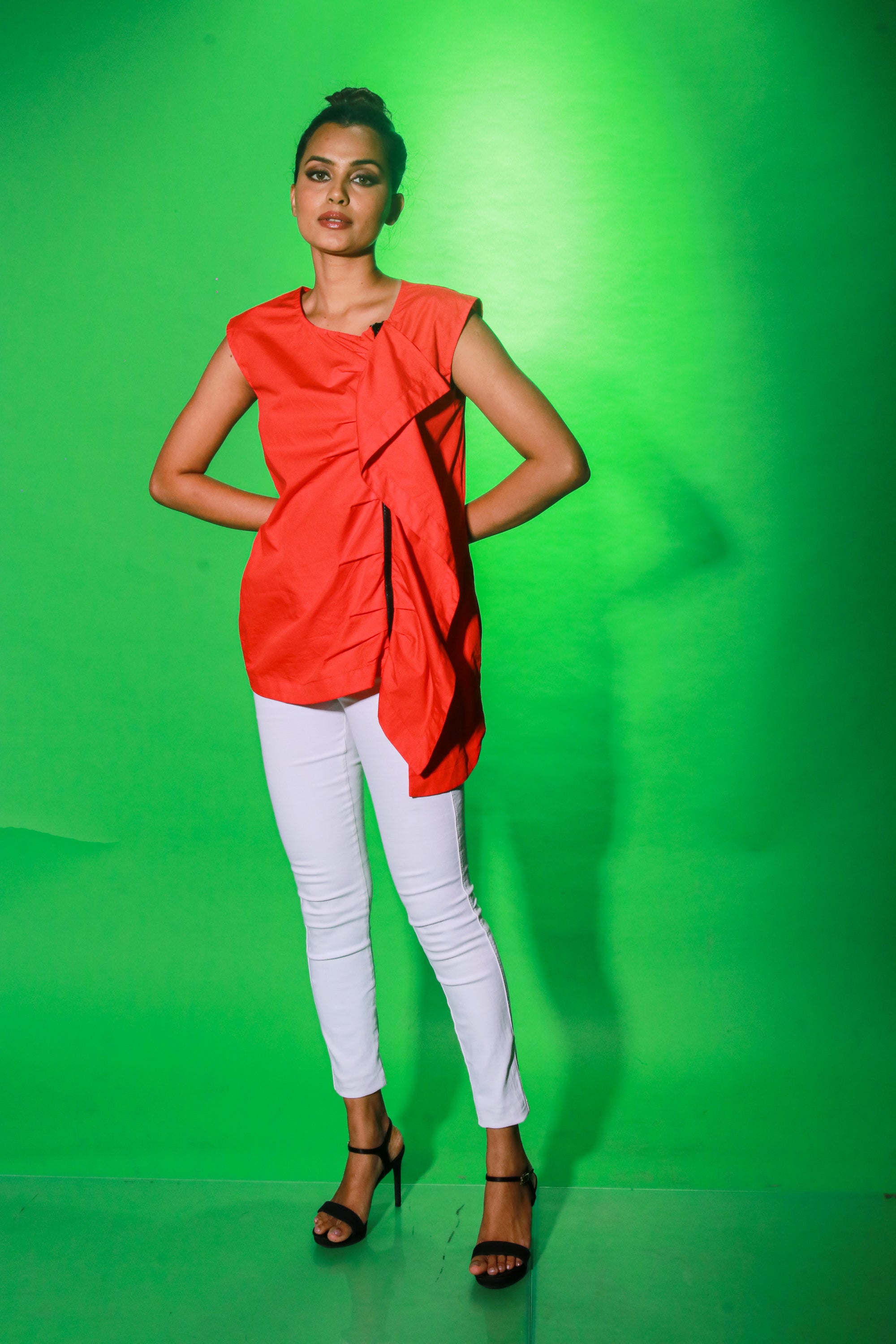 Coral sleeveless top features an off center zipper placket and frill detailing.