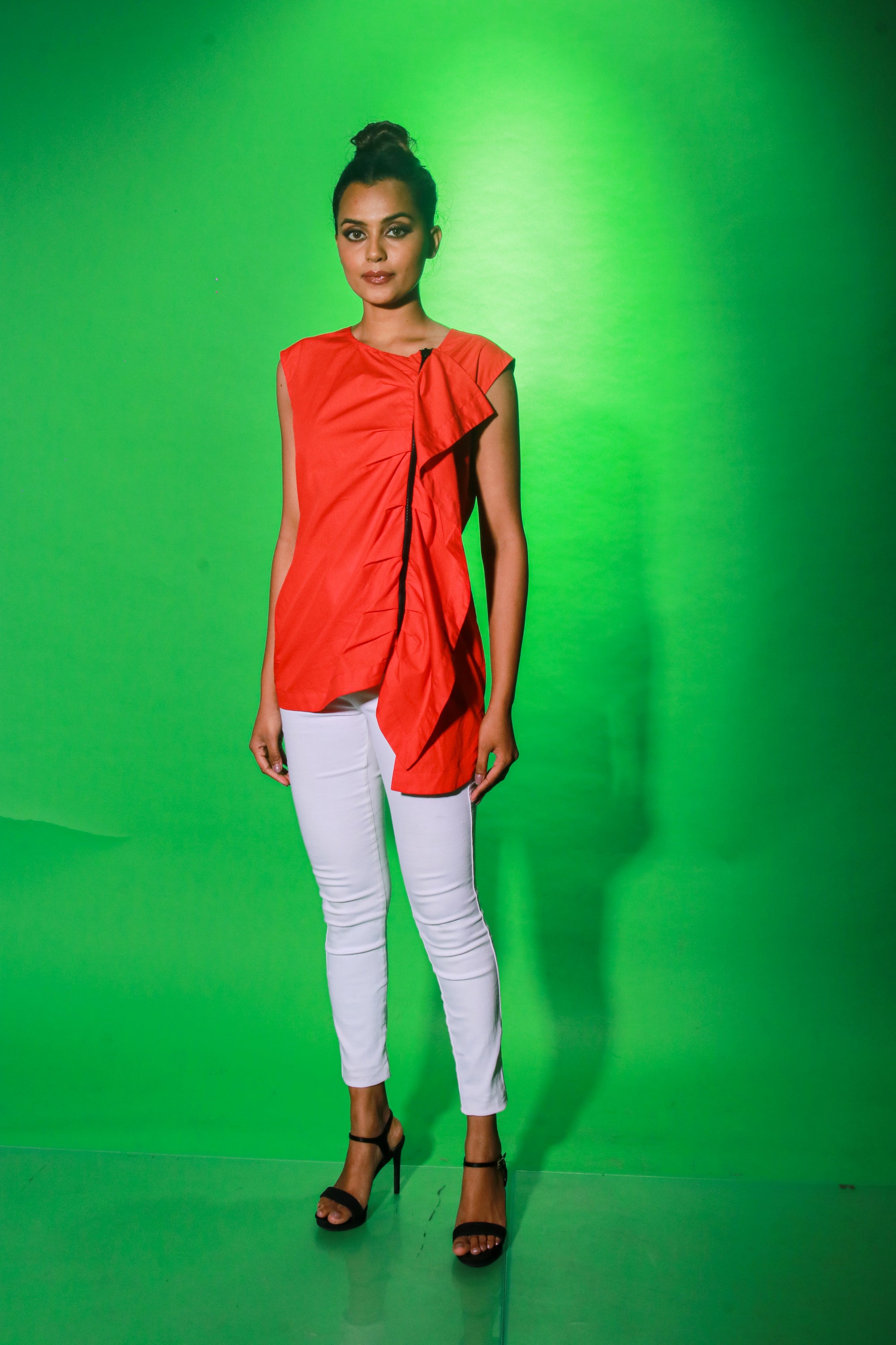 Coral sleeveless top features an off center zipper placket and frill detailing.