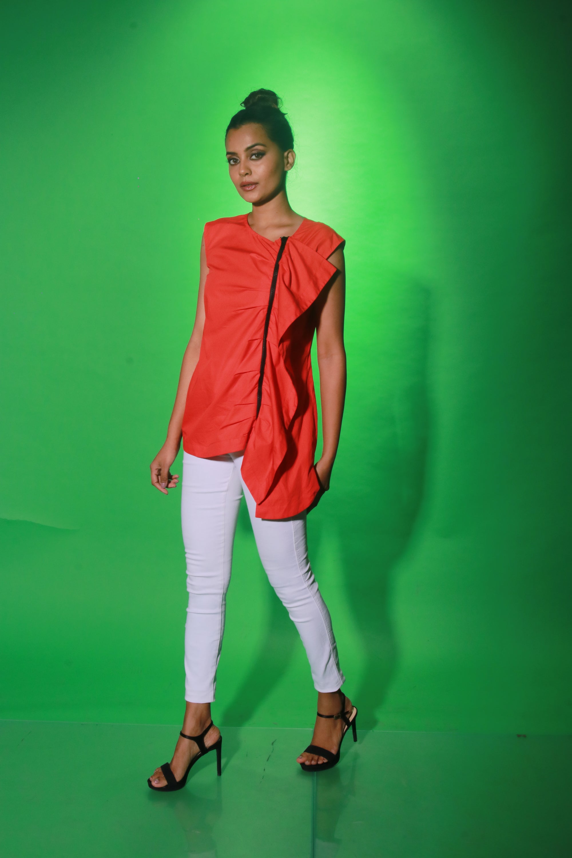 Coral sleeveless top features an off center zipper placket and frill detailing.