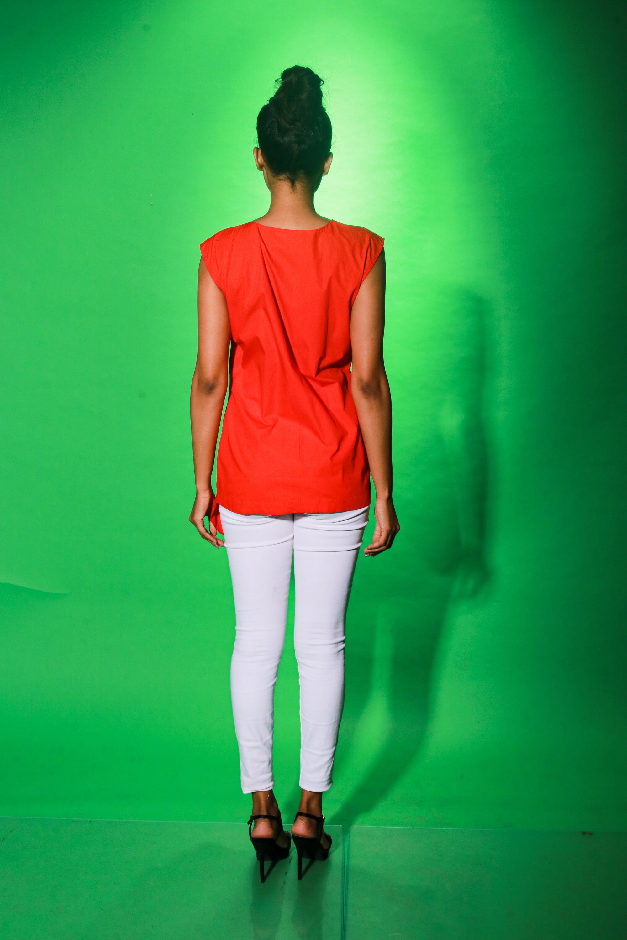 Coral sleeveless top features an off center zipper placket and frill detailing.