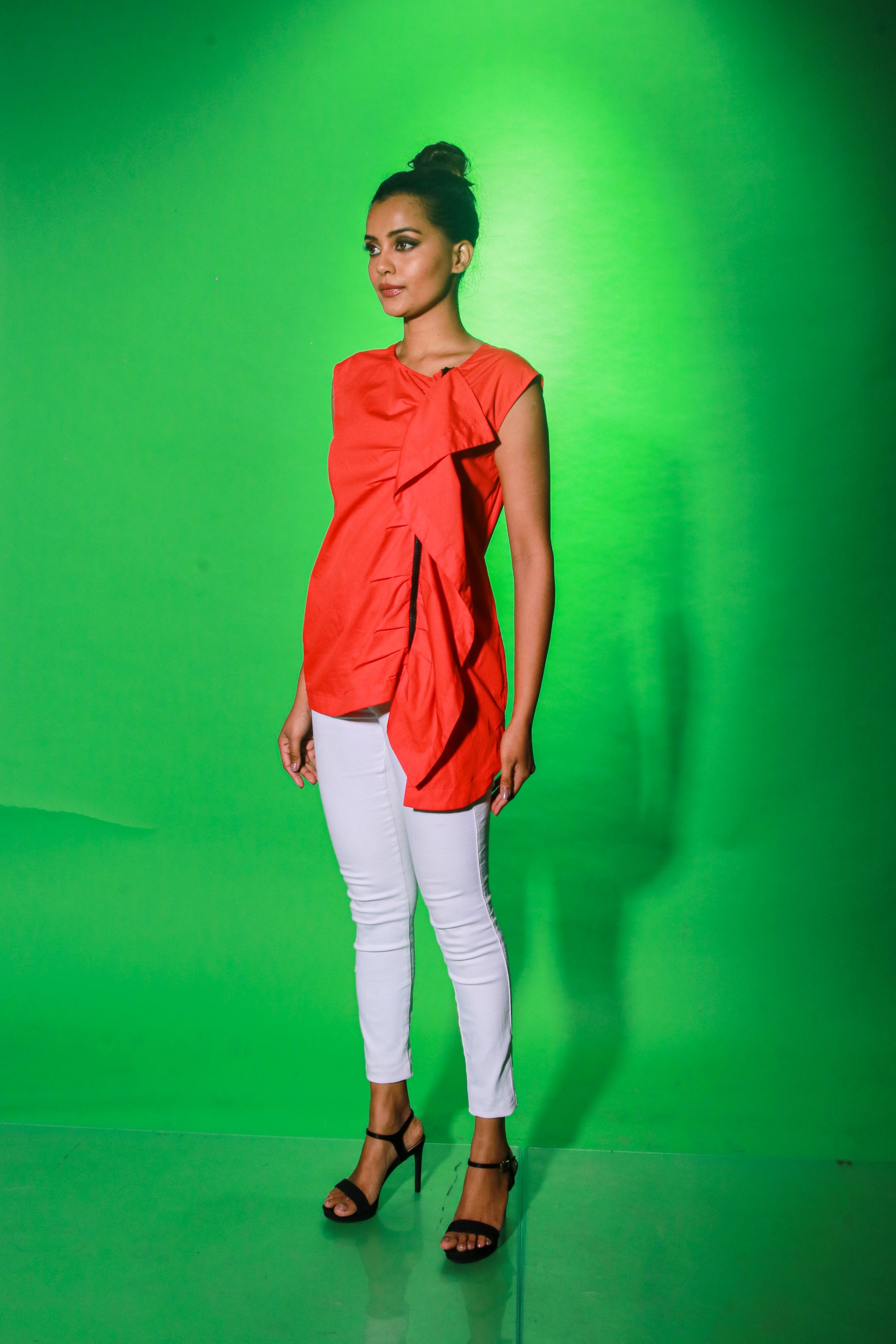 Coral sleeveless top features an off center zipper placket and frill detailing.