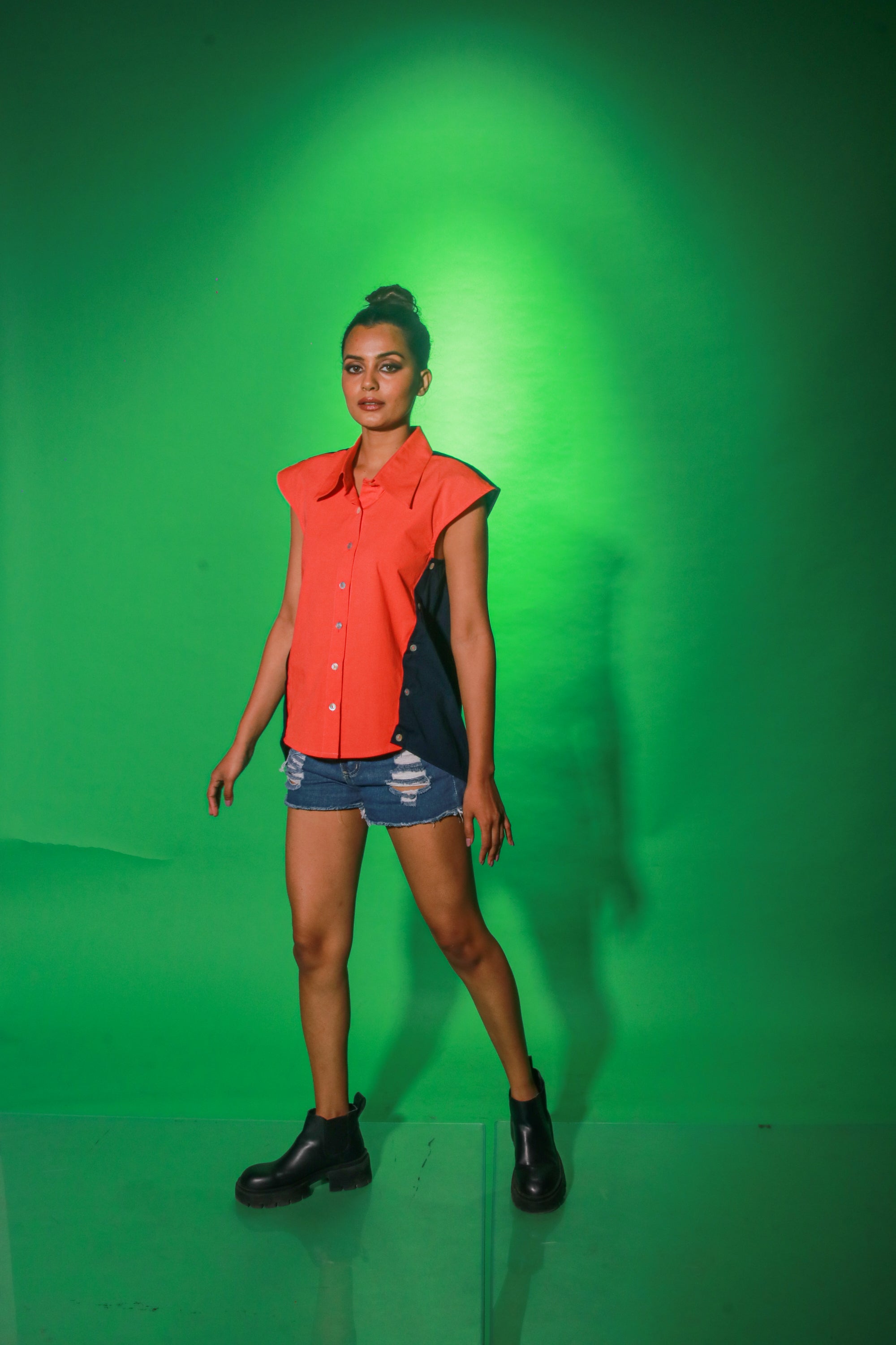 Coral and navy blue sleeveless top features collar and button detailing on both sides of the buttoned placket.