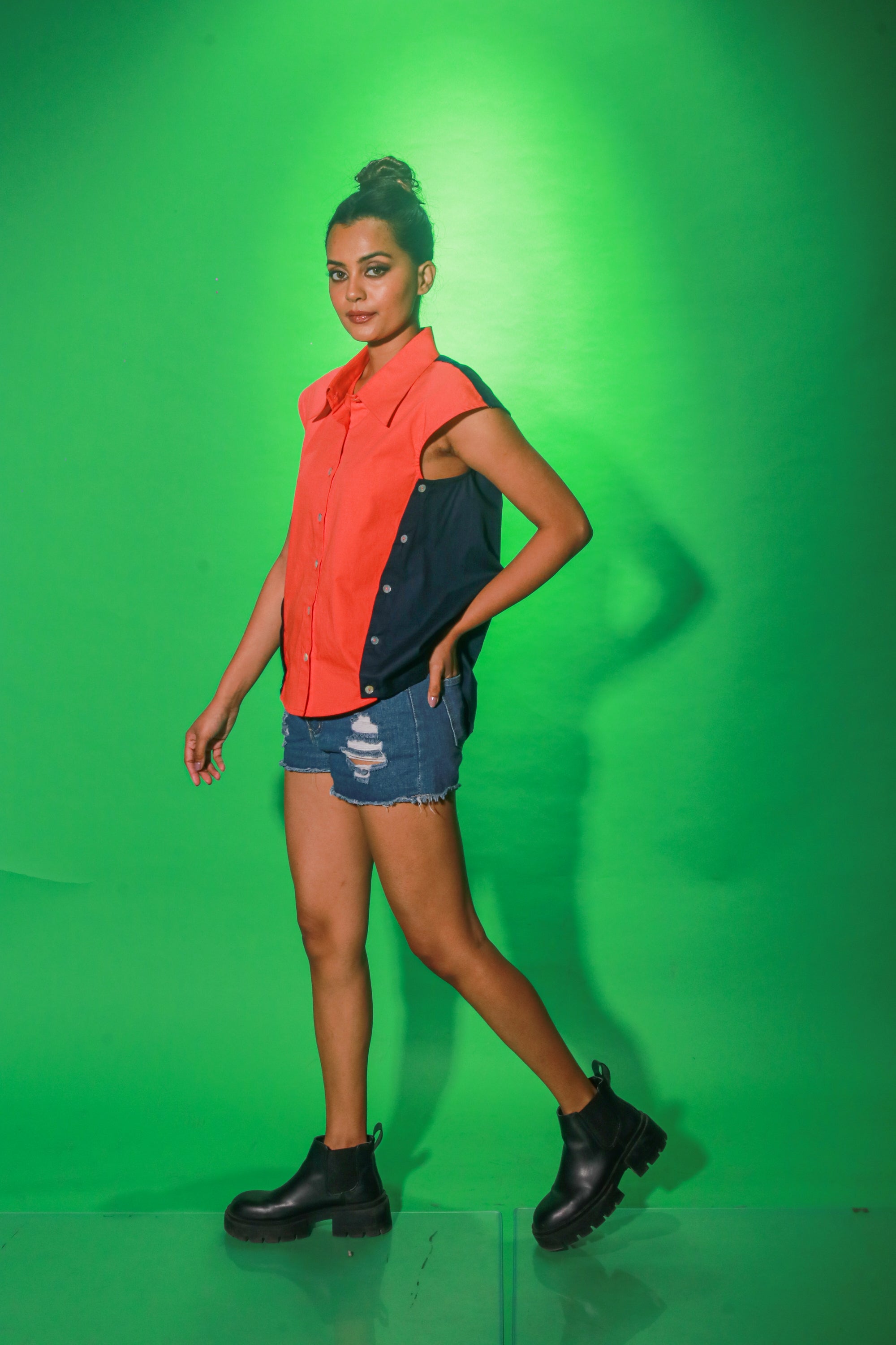 Coral and navy blue sleeveless top features collar and button detailing on both sides of the buttoned placket.