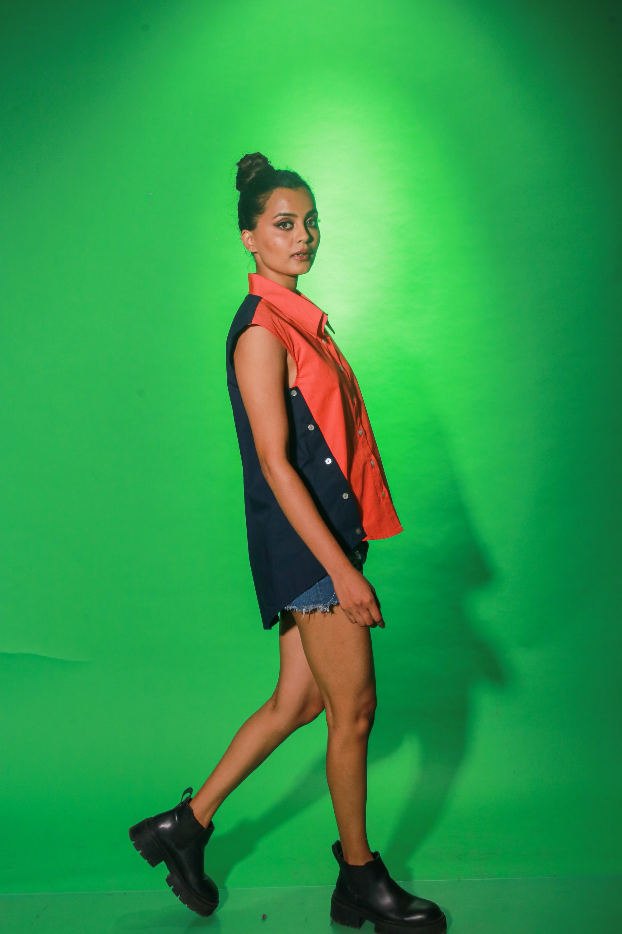 Coral and navy blue sleeveless top features collar and button detailing on both sides of the buttoned placket.