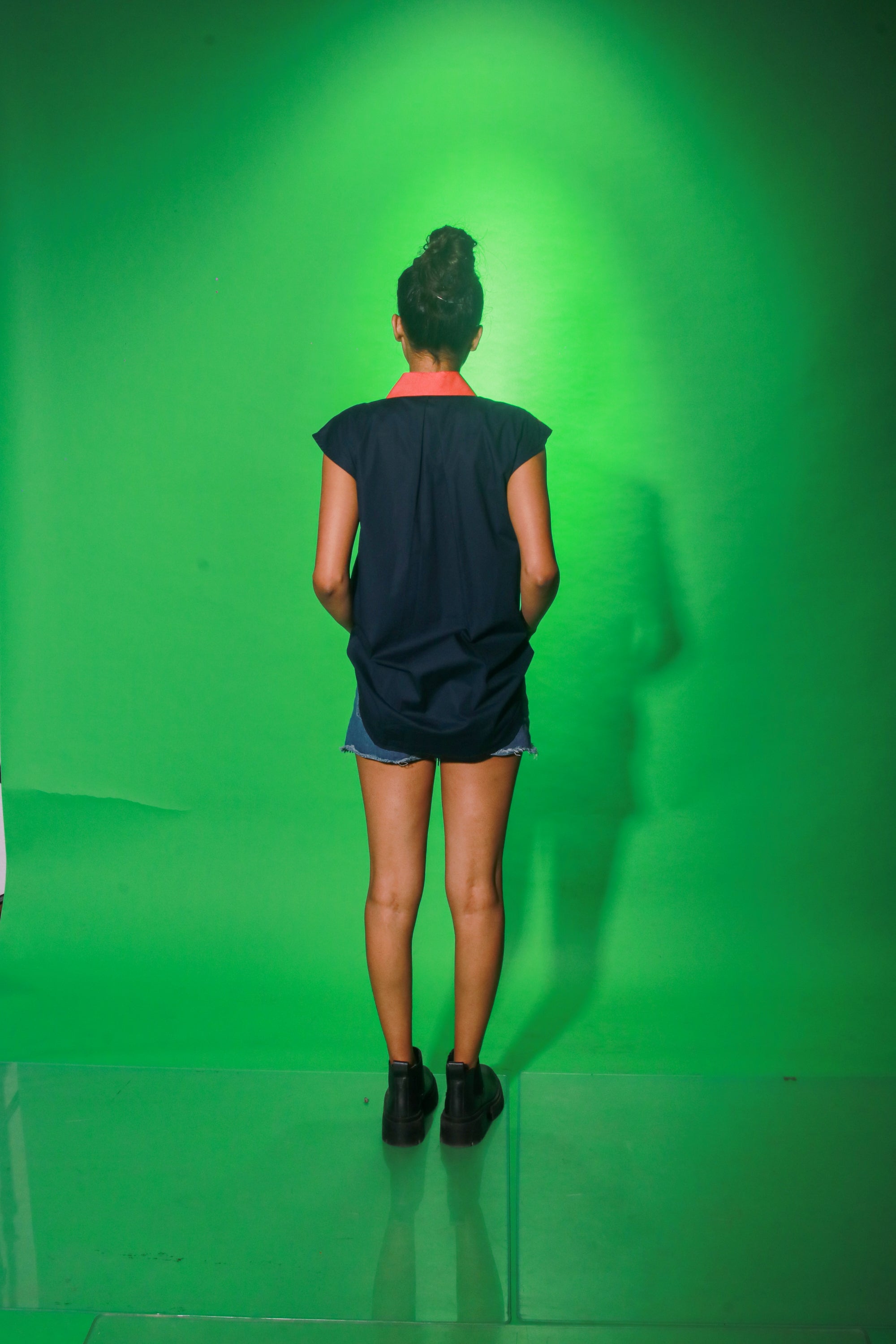 Coral and navy blue sleeveless top features collar and button detailing on both sides of the buttoned placket.