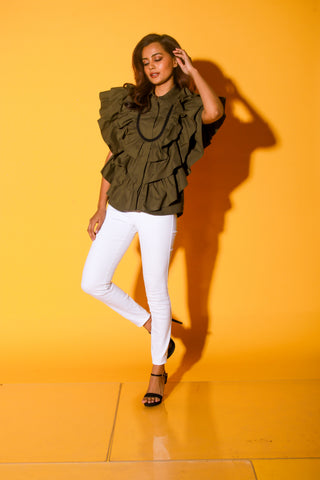 Olive green shirt features ruffles and black pipeing on the yoke.