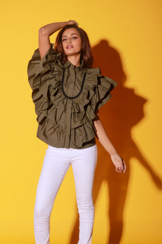 Olive green shirt features ruffles and black pipeing on the yoke.