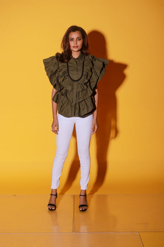 Olive green shirt features ruffles and black pipeing on the yoke.