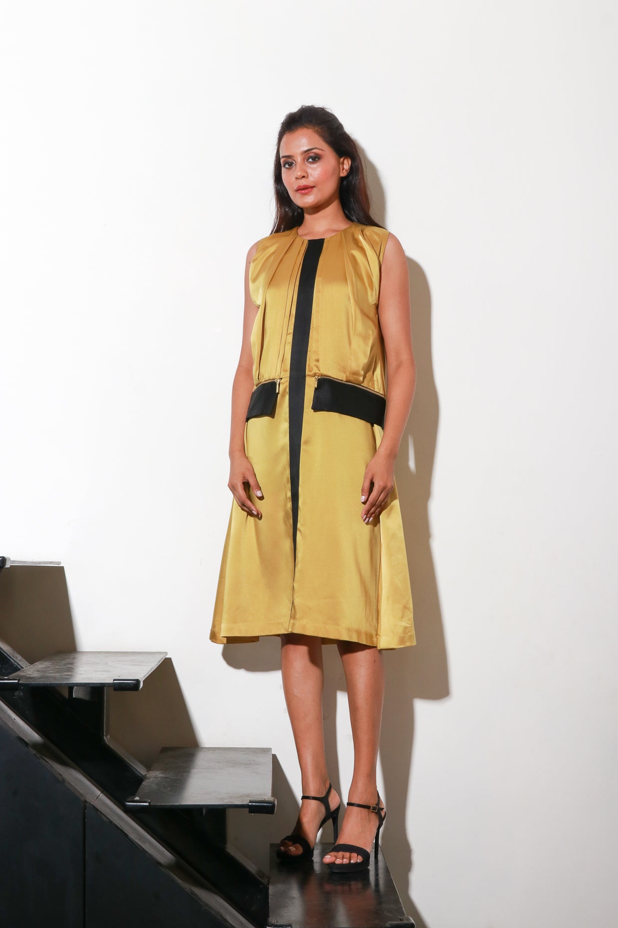 Mustard satin dress with pleats and paneled feature with black satin panel, and side zipper.