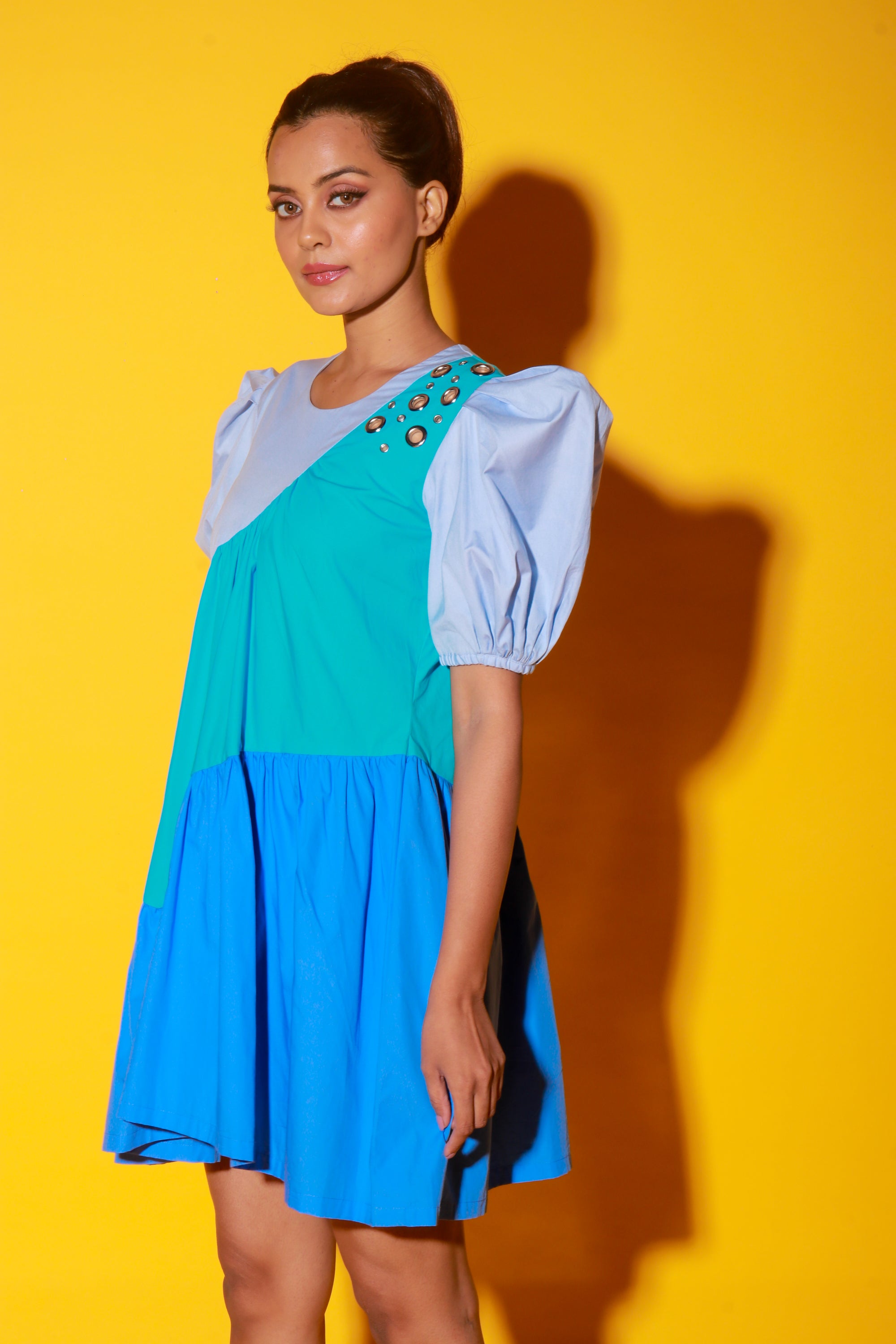 Turquoise, slate and powder blue short dress features balloon sleeves and eyelet feature on one shoulder.