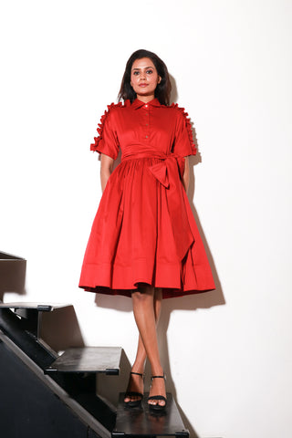 Red lady dress with waist flare and ruffle feature on shoulders and sleeves.