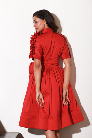 Red lady dress with waist flare and ruffle feature on shoulders and sleeves.