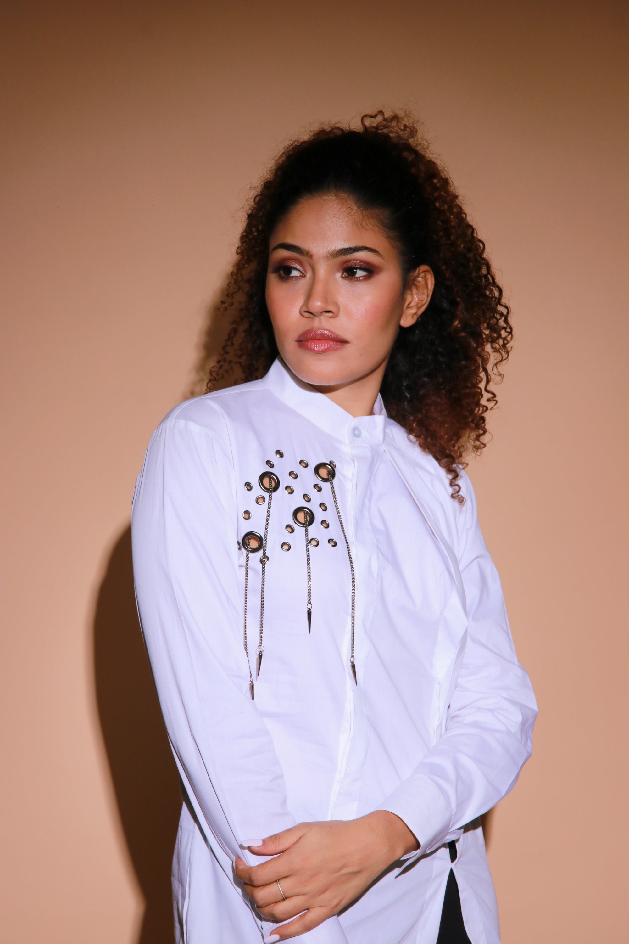White top features an open side flap and eyelet and chains embellishment.