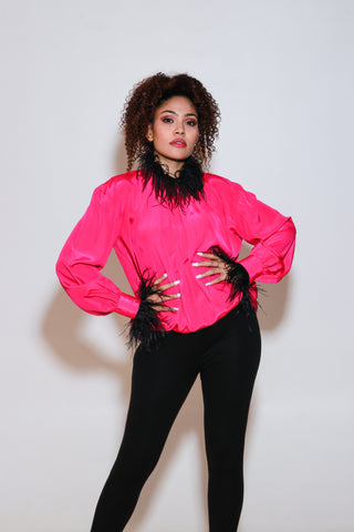 Fuchsia pink top has black fur trim on the neckline and sleeves.