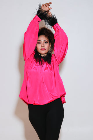 Fuchsia pink top has black fur trim on the neckline and sleeves.