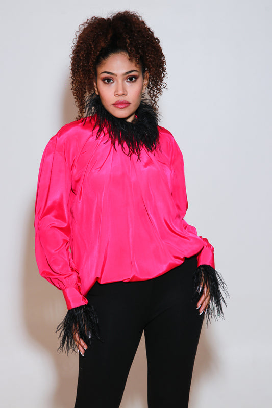 Fuchsia pink top has black fur trim on the neckline and sleeves.