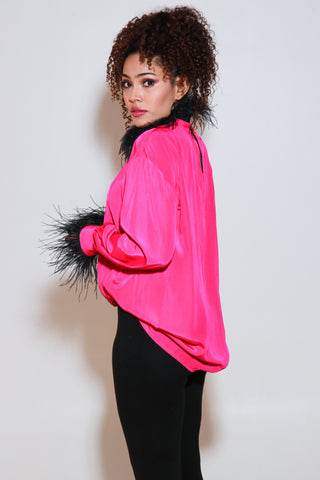 Fuchsia pink top has black fur trim on the neckline and sleeves.