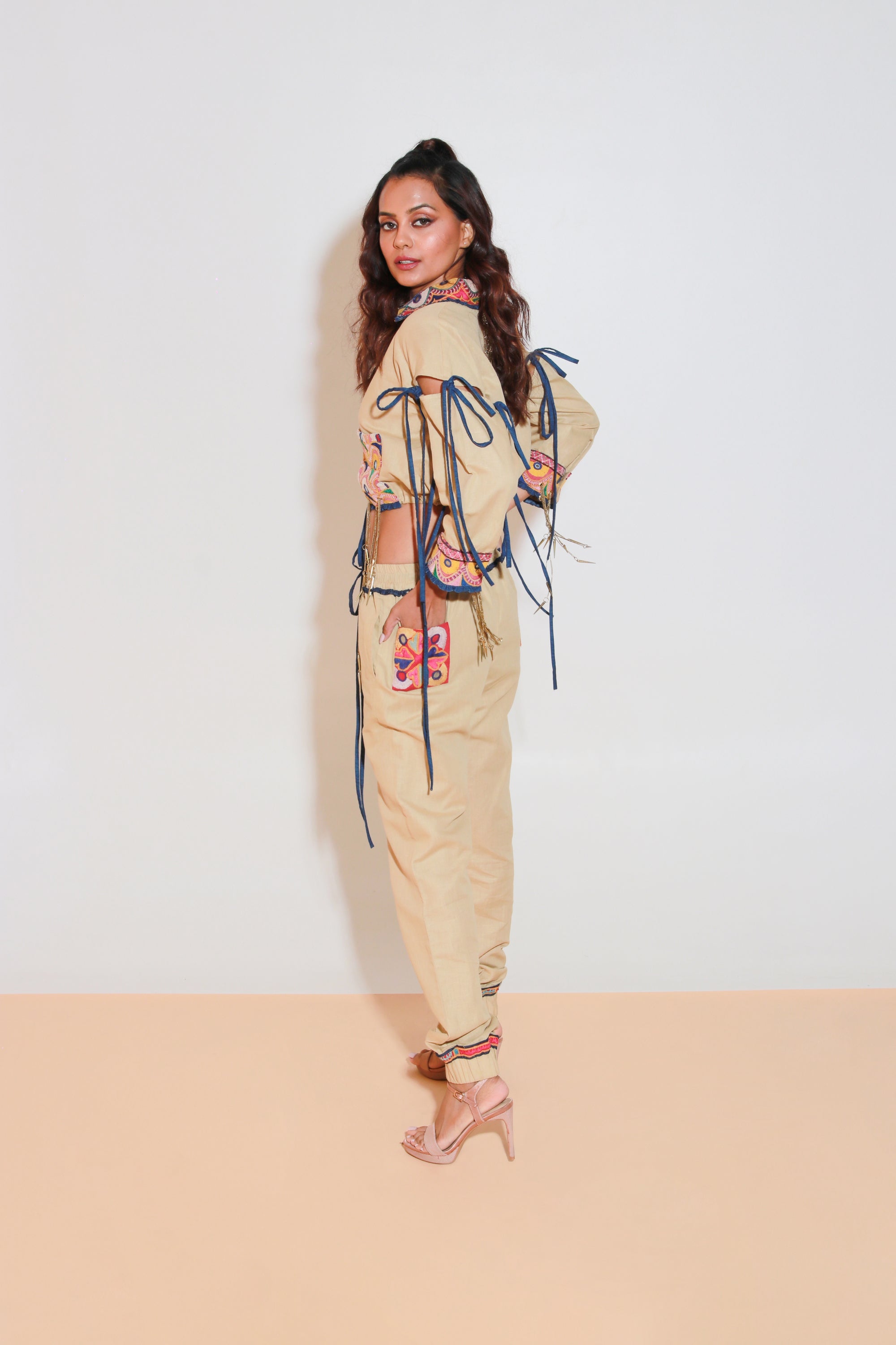 Denim and khaki tie-up crop top with Kutch border, detachable sleeves, and matching jogger pants with Kutch border accents.