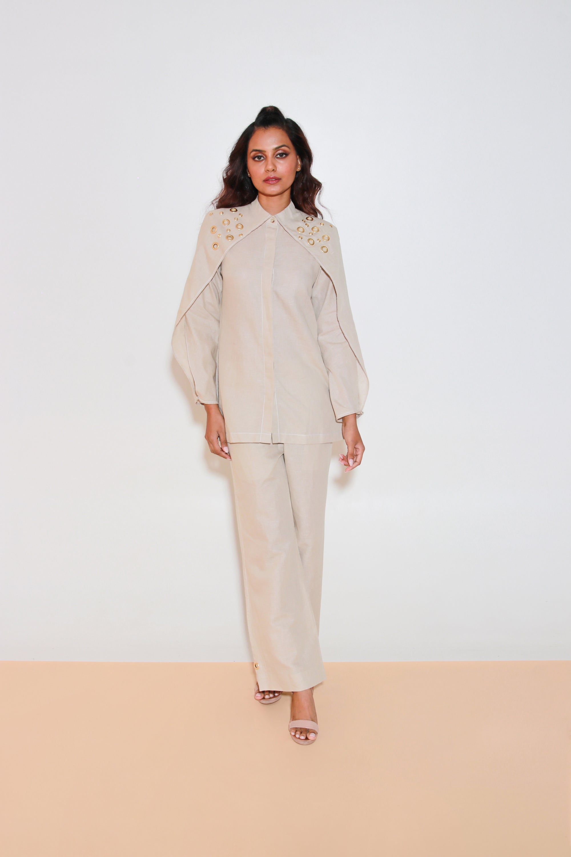 Ecru co-ord set is crafted in pure linen and features a top with eyelet collar, flap sleeves and straight pants.