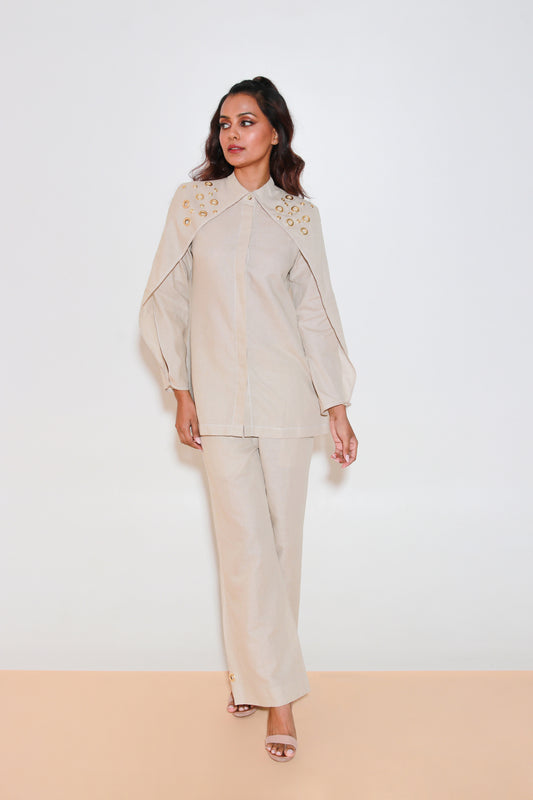 Ecru co-ord set is crafted in pure linen and features a top with eyelet collar, flap sleeves and straight pants.