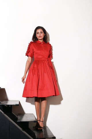 Red lady dress with waist flare and ruffle feature on shoulders and sleeves.