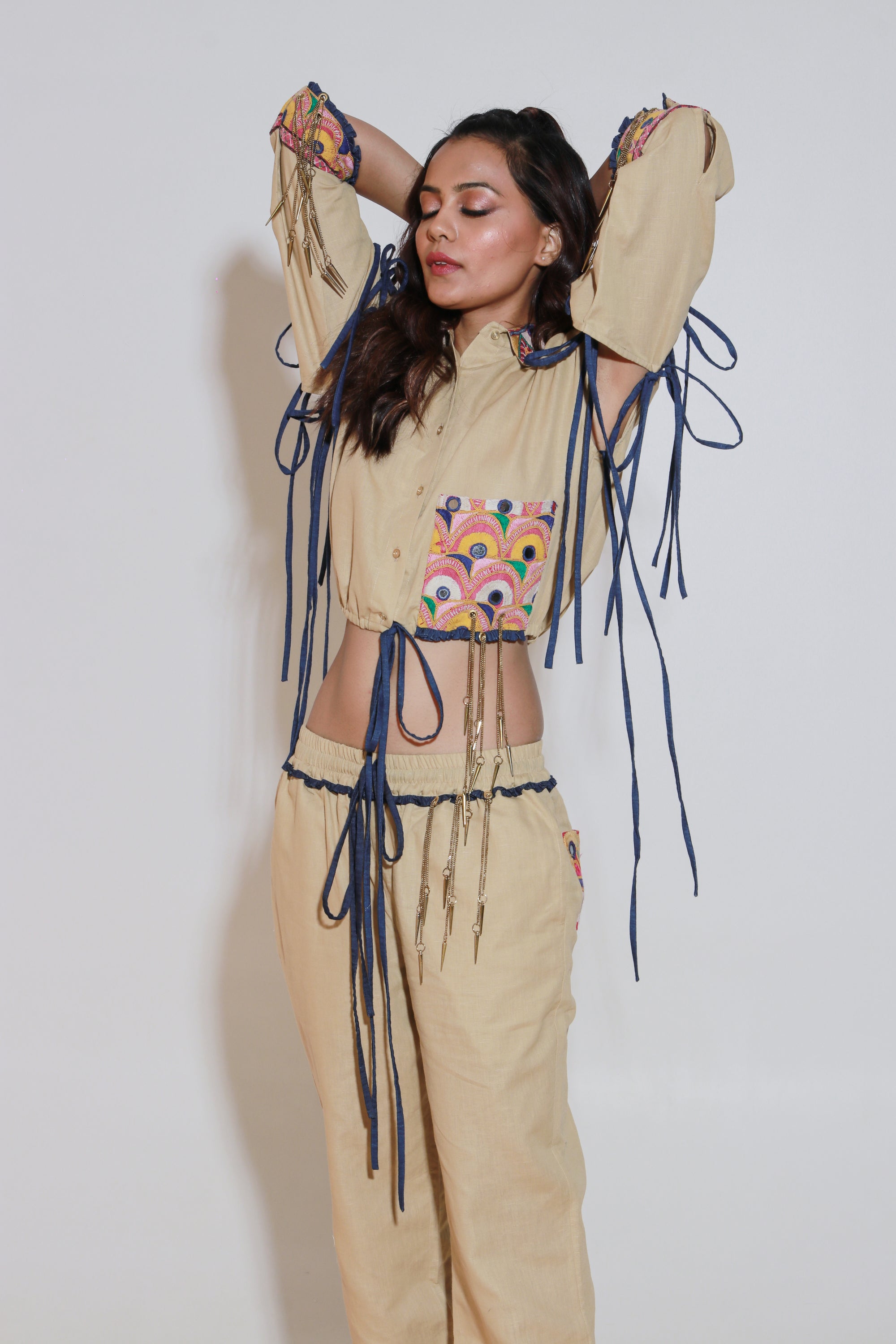 Denim and khaki tie-up crop top with Kutch border, detachable sleeves, and matching jogger pants with Kutch border accents.