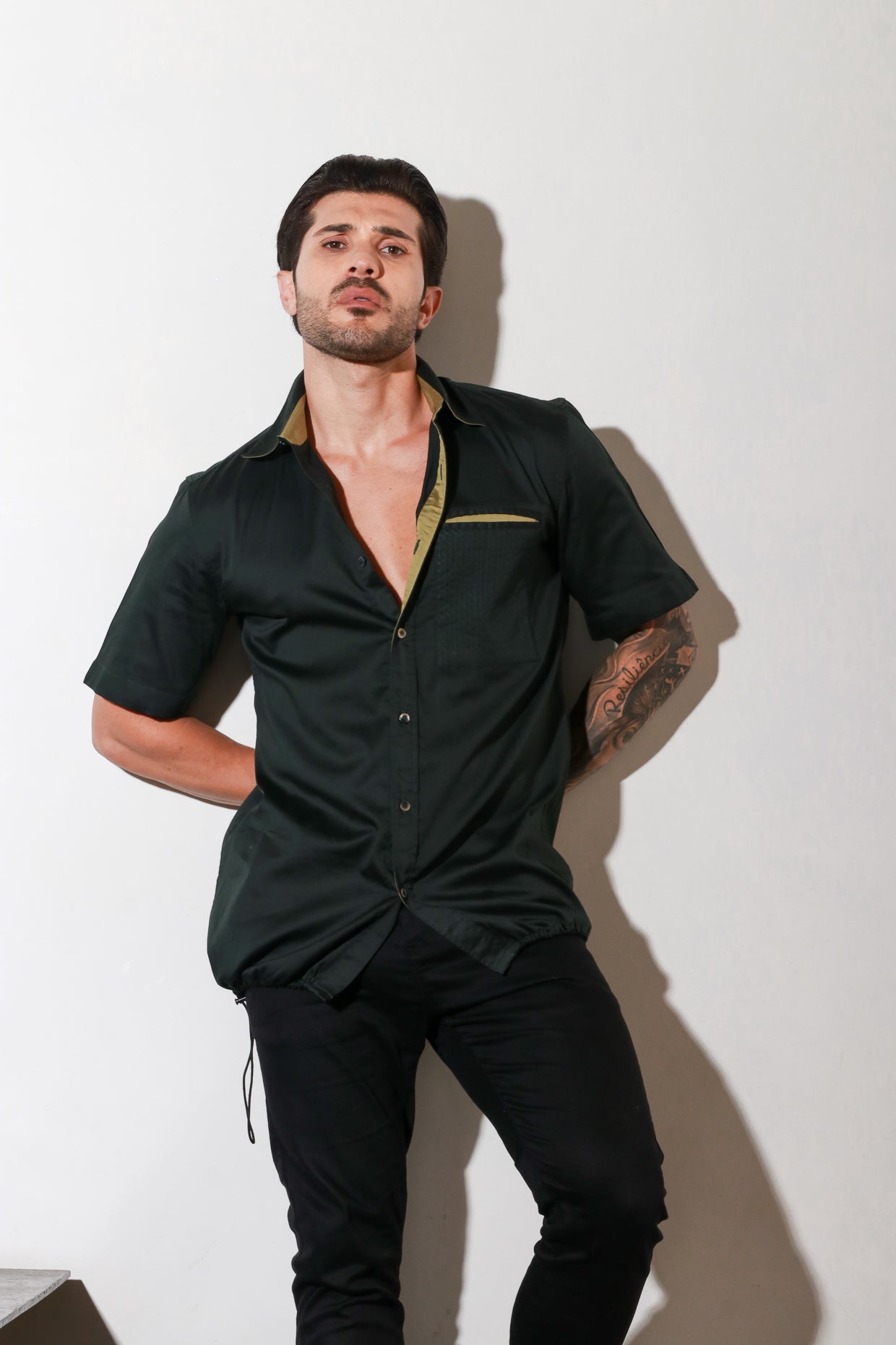 Dark green half sleeve shirt with contrast detailing and elasticated bottom feature.