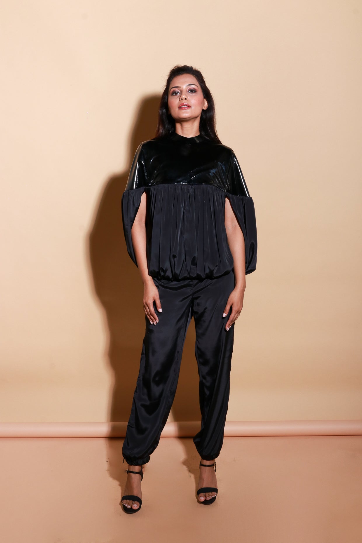 Patent leather half and satin half gathered top with balloon feature with track pants with side zipper accents.