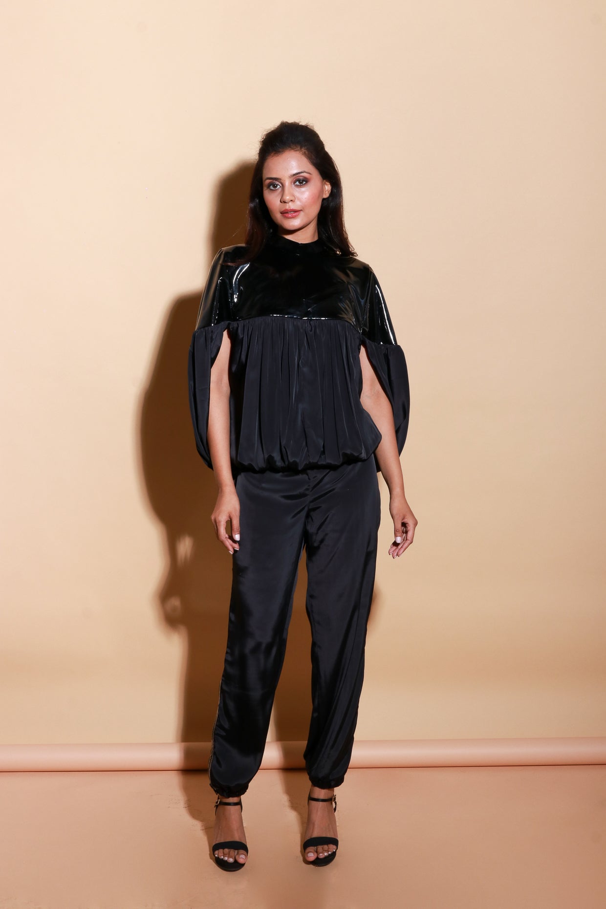 Patent leather half and satin half gathered top with balloon feature with track pants with side zipper accents.