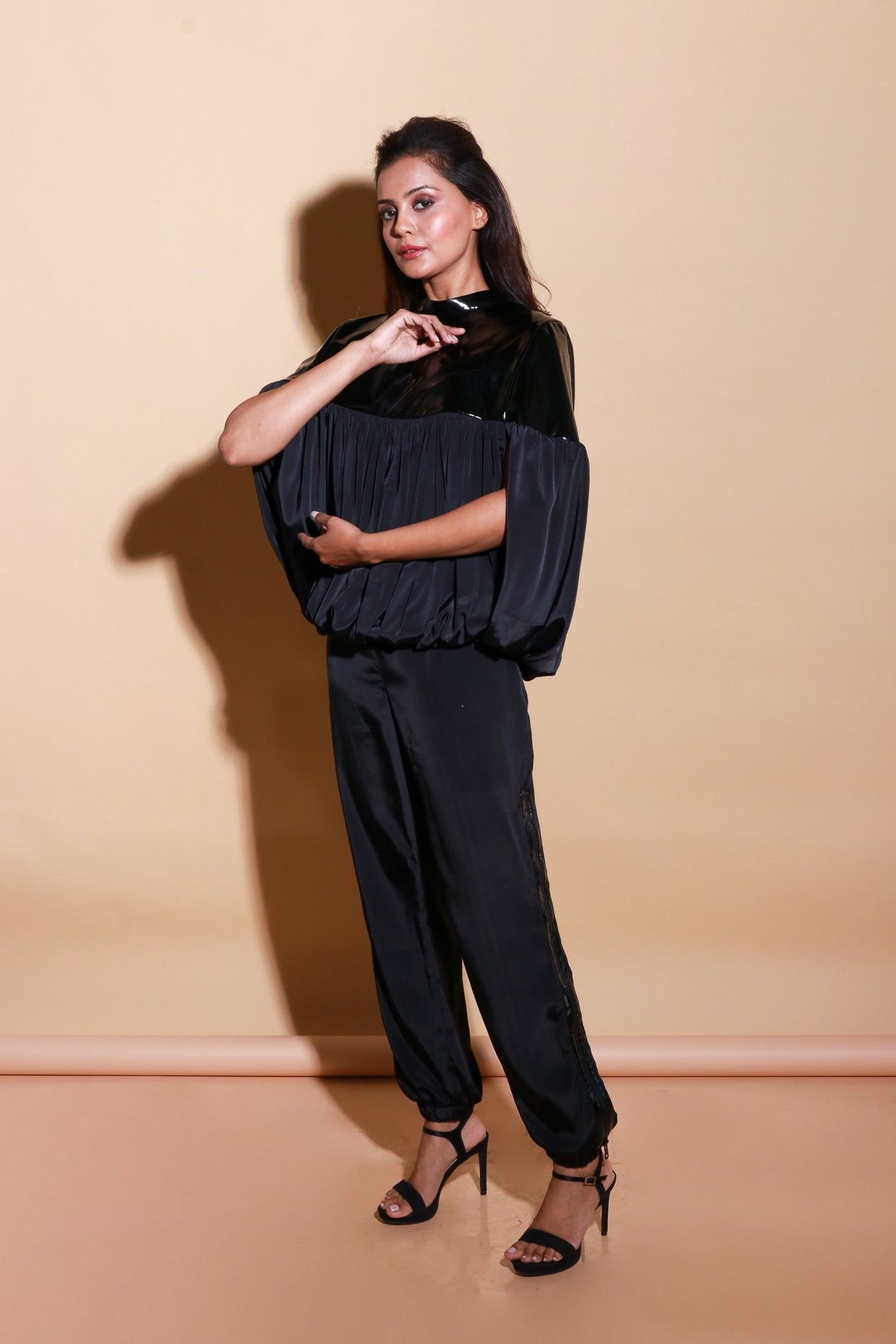 Patent leather half and satin half gathered top with balloon feature with track pants with side zipper accents.
