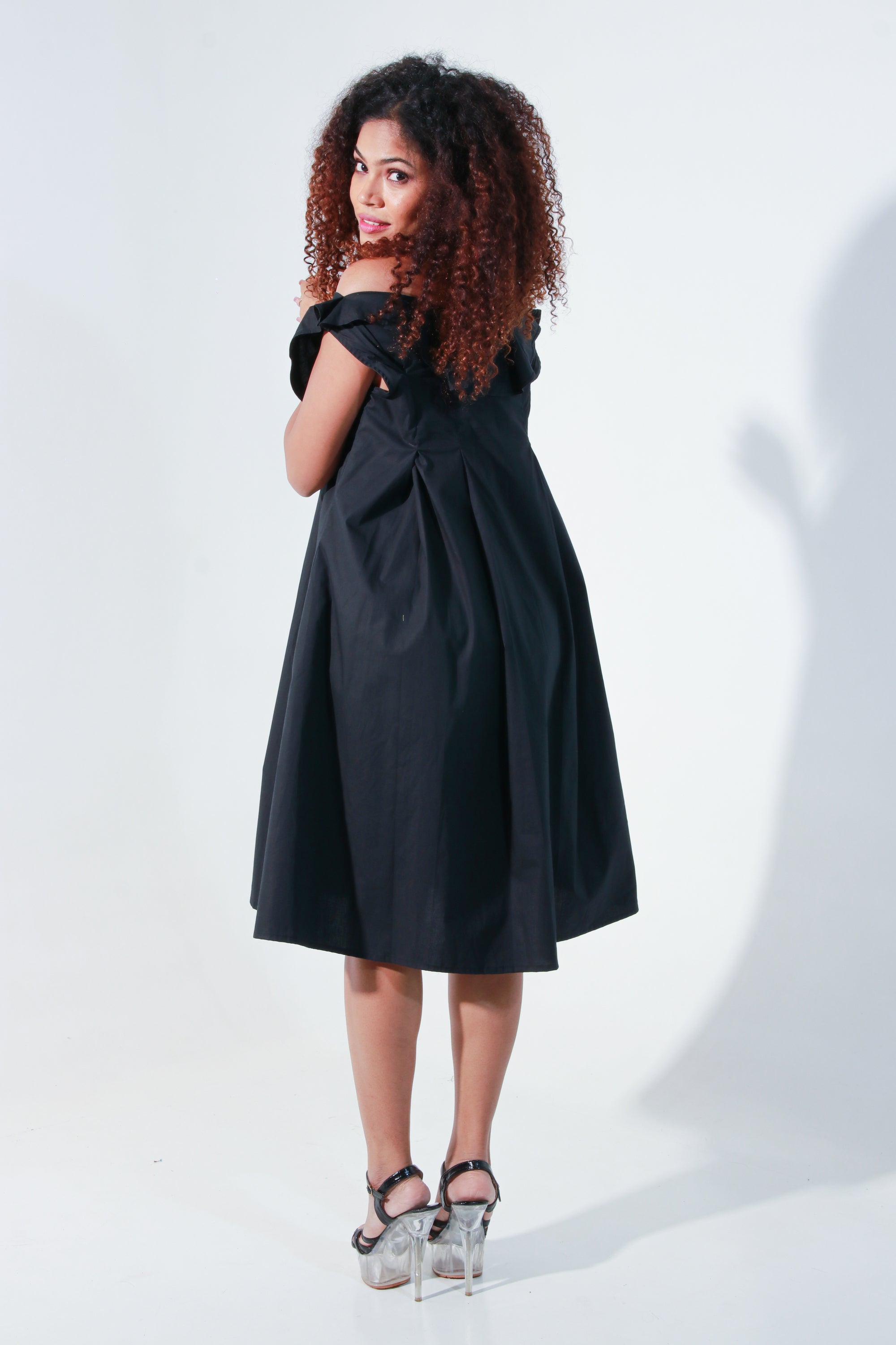Black off shoulder knee length dress with pleated neck detailing.