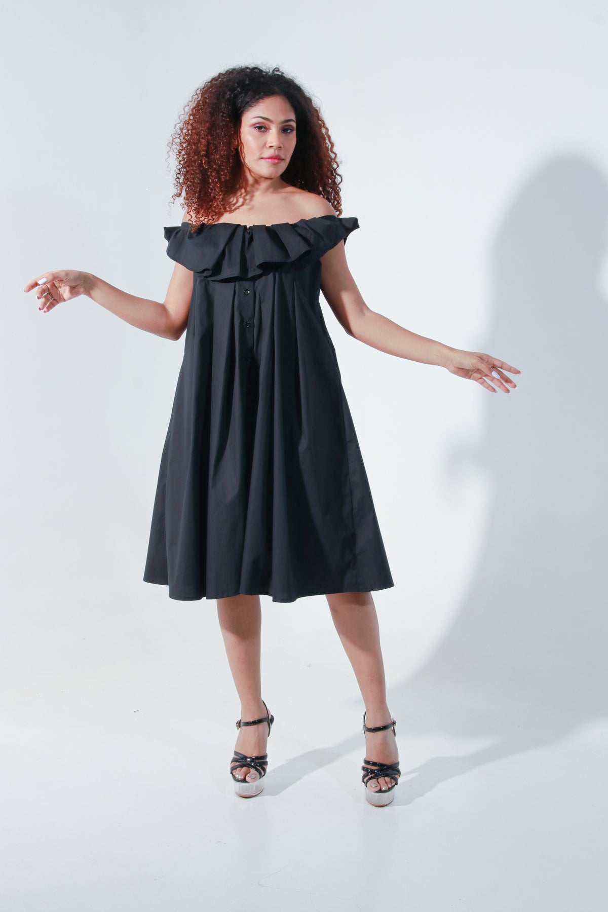 Black off shoulder knee length dress with pleated neck detailing.