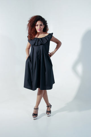 Black off shoulder knee length dress with pleated neck detailing.