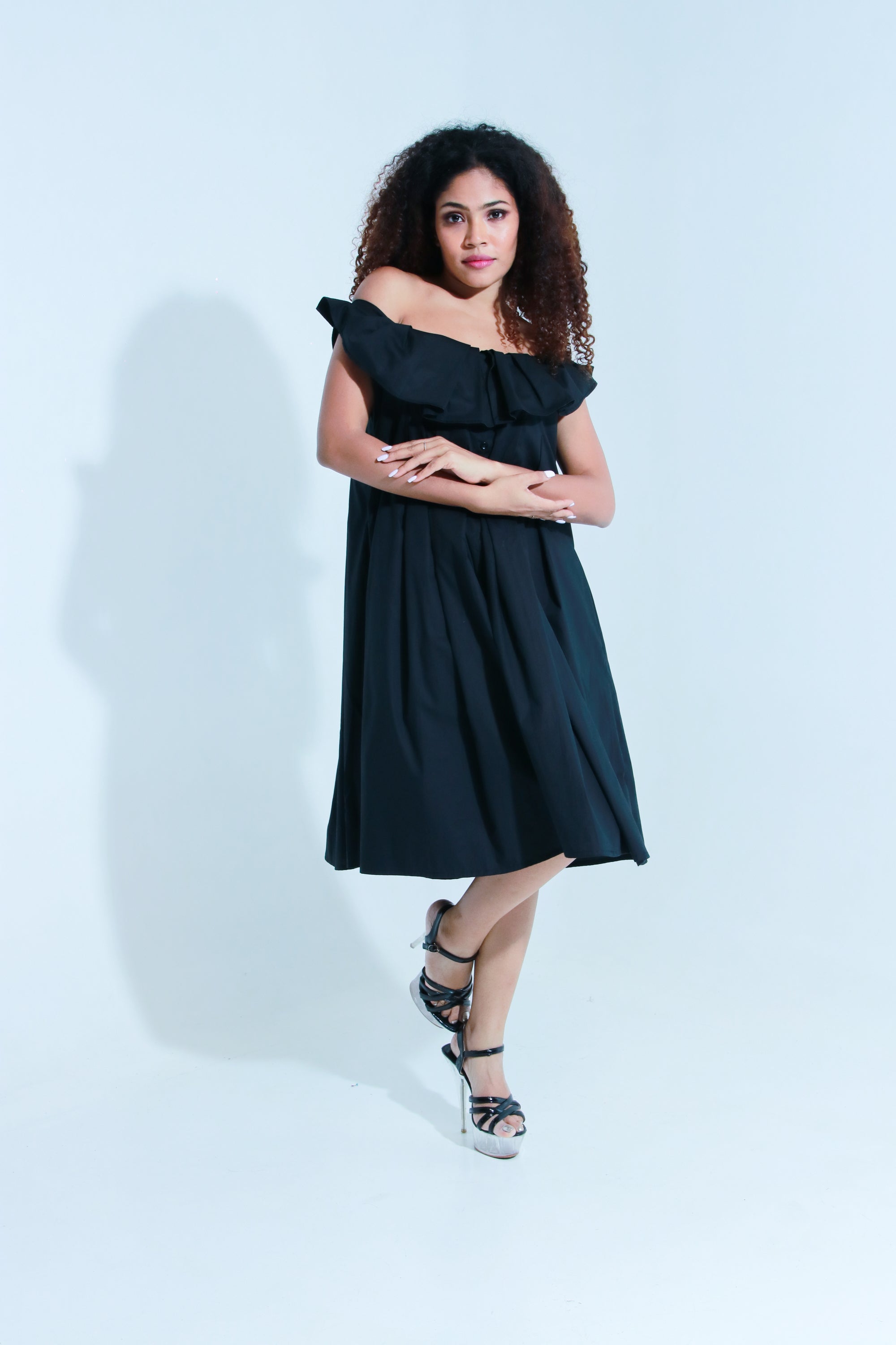 Black off shoulder knee length dress with pleated neck detailing.