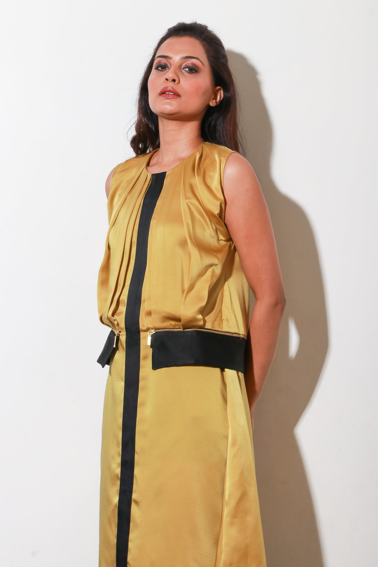 Mustard satin dress with pleats and paneled feature with black satin panel, and side zipper.